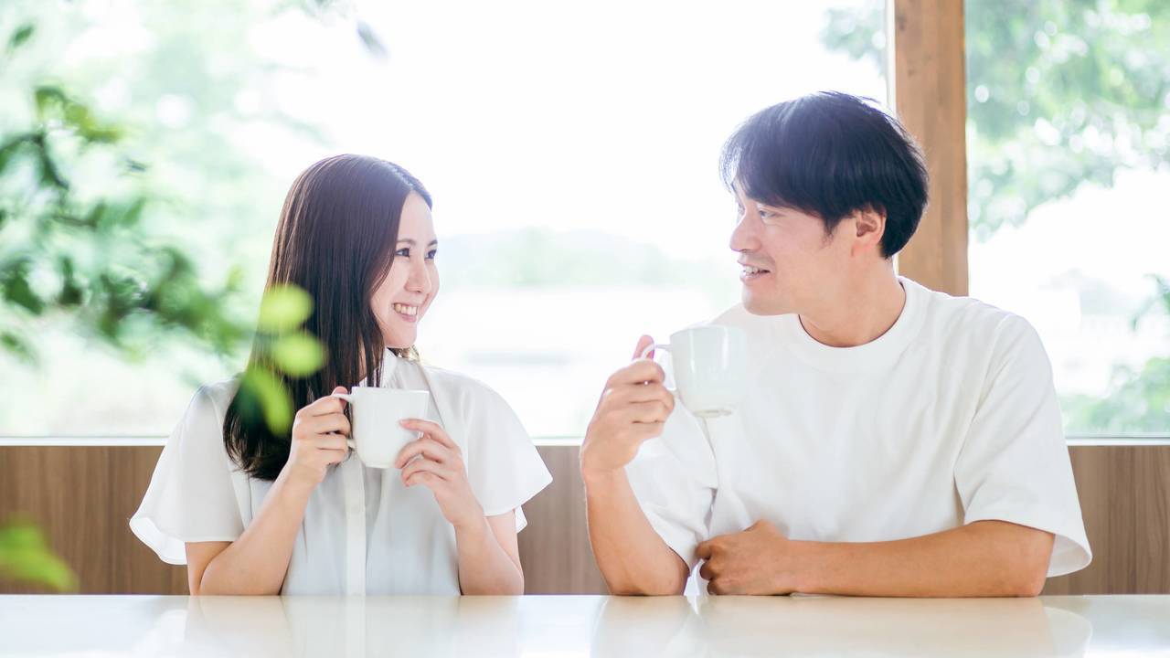 窓辺で笑顔の会話を楽しむ二人のイメージ